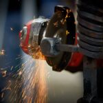 Dynamic close-up of an angle grinder in action, emitting bright sparks as it shapes metal.