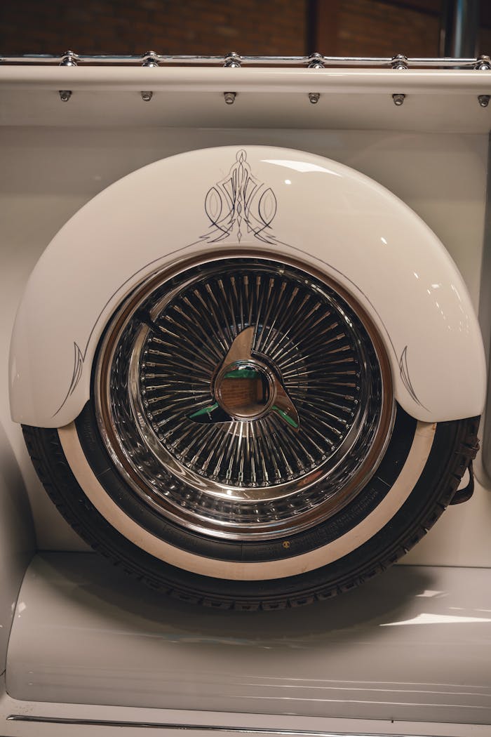 Detailed view of a vintage car's wheel with stylish decorative elements, perfect for automotive themes.